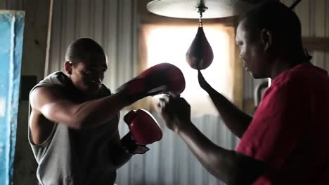 coach and boxer practicing boxing in the gym