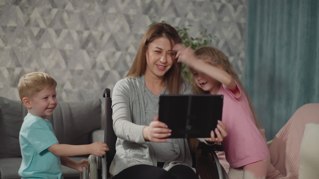 madre feliz toma selfies con niños activos en una tableta moderna