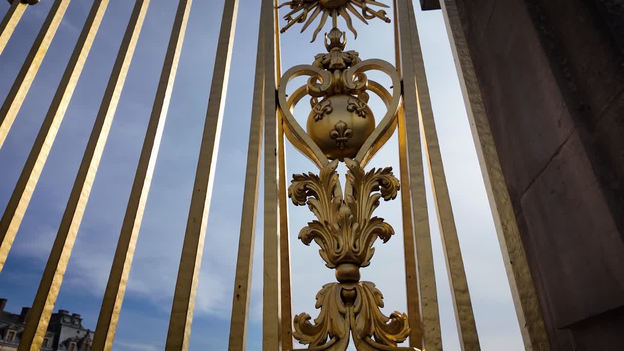 Cinematic 4K descending shot showing the ornate ironwork details of the main gate of the Palace of Versailles, an iconic landmark near Paris, France