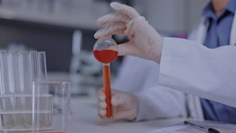 hands, lab and beaker with test tube