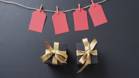 video of gift tags on string, gift boxes with ribbons and copy space on black background