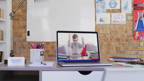 niño de escuela caucásico aprendiendo mostrado en la pantalla del portátil durante una videollamada