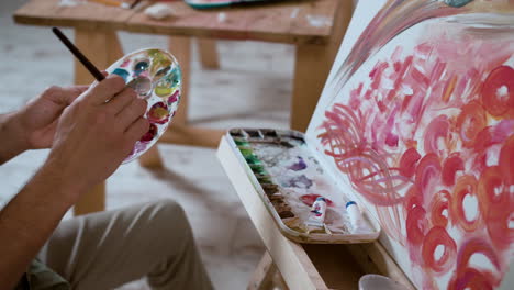 Man-sitting,-doing-a-painting