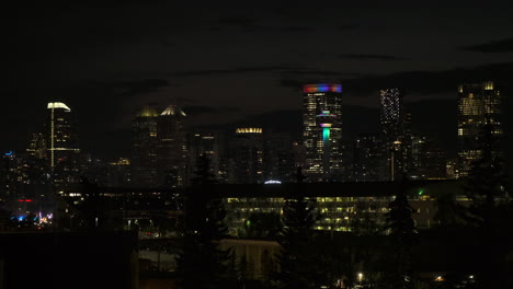 calgary tower and downtown skyscrapers lit up on dark city night