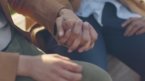 close up of loving muslim couple on date sitting and holding hands