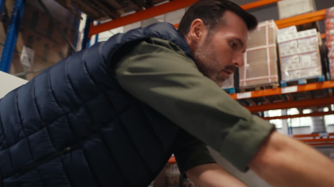 hombre caucásico adulto empaquetando una mercancía en una carretilla elevadora