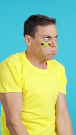 man cheering for jamaica, angry with the decision of referee