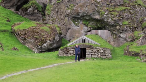 hombre que se aleja de la cabaña de piedra en la montaña 4k