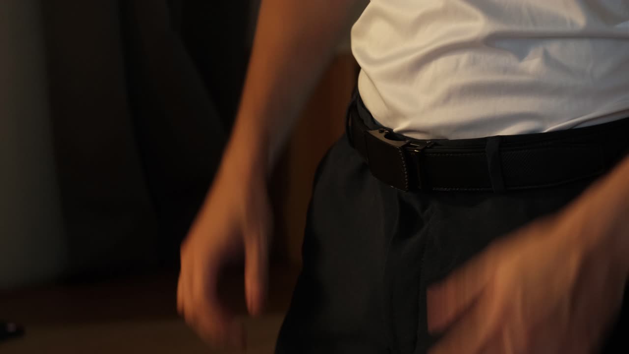Homem cortado vestindo camisa branca e cinto com catraca. Close-up