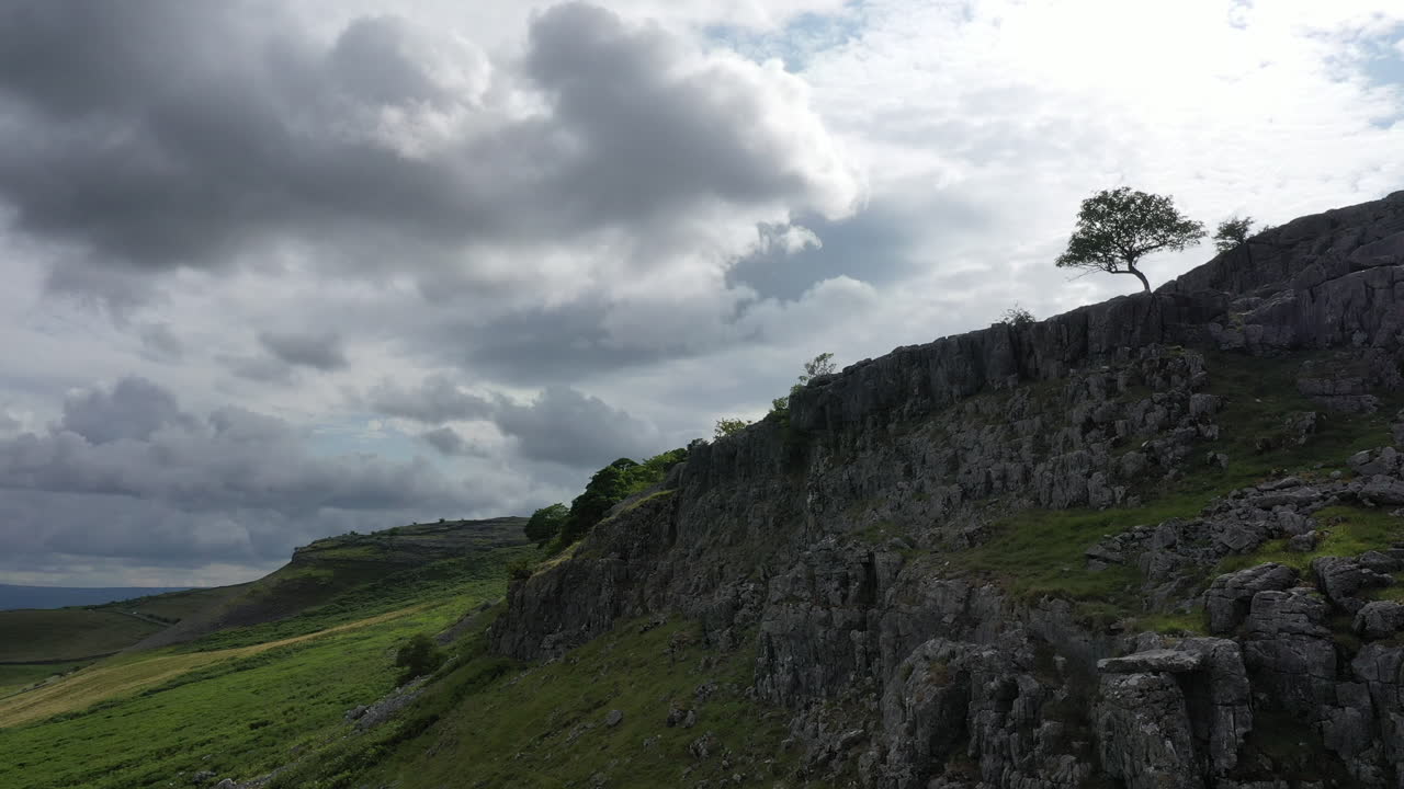 Drone footage looking at hawthorn tree on a ridge and panning left and down over the yorkshire dales