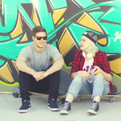 Young-hipster-urban-couple-relaxing-on-a-sidewalk