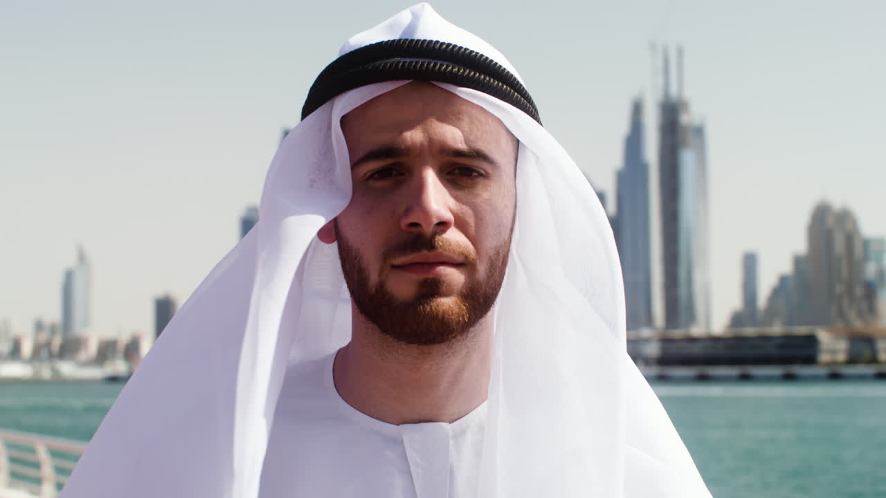 아랍 의 옷 을 입은 남자 가 야외 에서 포즈 를 취 하고 있다