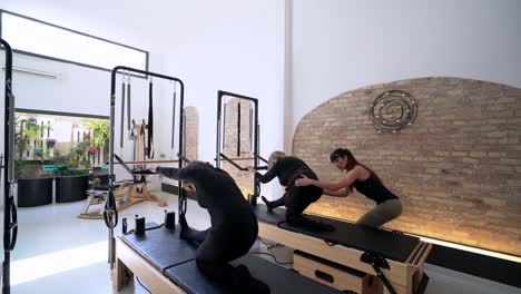 Frauen-Machen-Während-Des-Trainings-Übungen-Auf-Dem-Pilates-Reformer