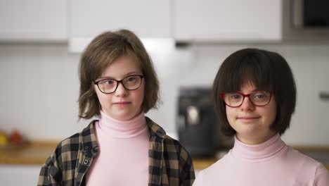 portrait of two happy girls with down syndrome in glasses