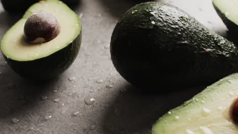 Micro-video-of-close-up-of-avocados-with-copy-space-on-grey-background