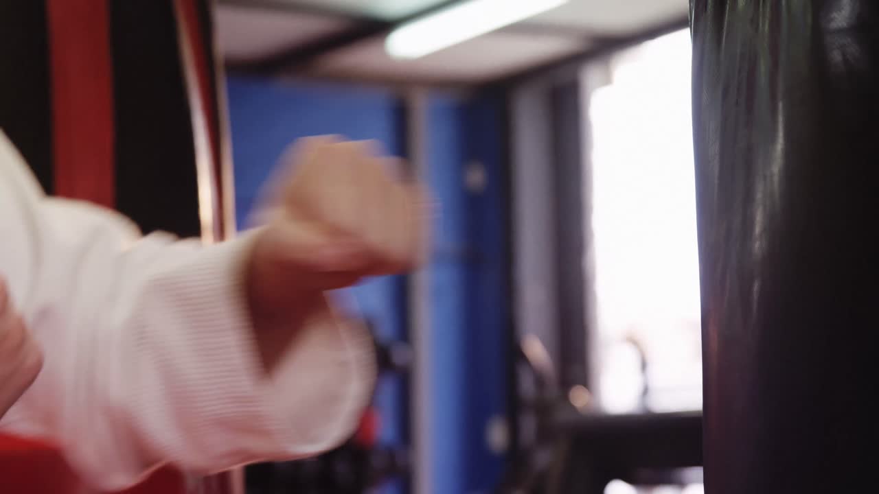 мужчина занимается карате с боксерским мешком.