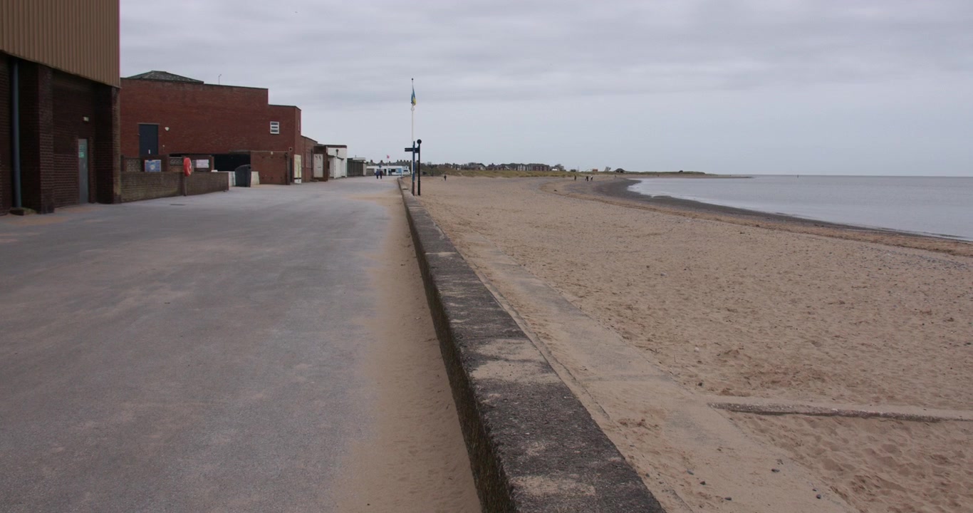 Vid zoom-innspilling som ser nedover den øde strandpromenaden i Fleetwood på Marina Beach