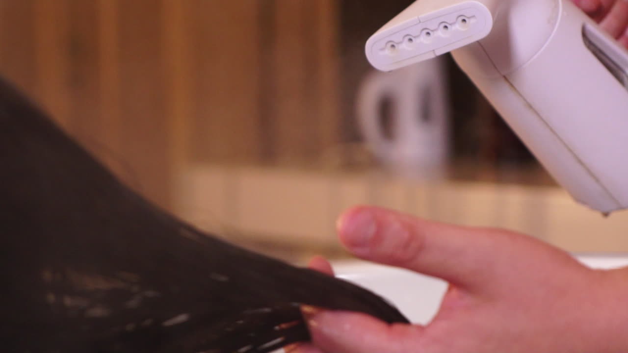 여자의 머리카락을 김이 나는 미용사