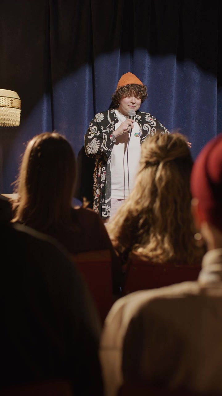 Female Standup Artist Walking on Stage and Telling Jokes to Audience