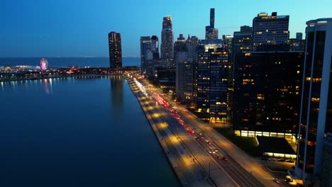 Drone-shot-of-a-busy-Lake-Shore-Drive-in-Chicago,-Illinois,-filmed-as-the-sun-goes-down