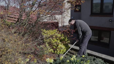 elderly man hoeing his garden enjoying the sun