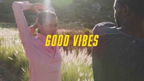 animation of the words good vibes written in yellow over couple exercising in mountains