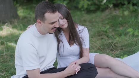 couple sitting on grass holding hands