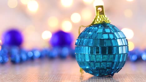 ornamento de vidrio de navidad azul con luces parpadeantes detrás