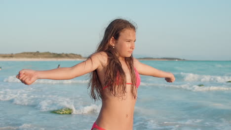 focused woman doing exercises at seashore. pretty girl training at beach.