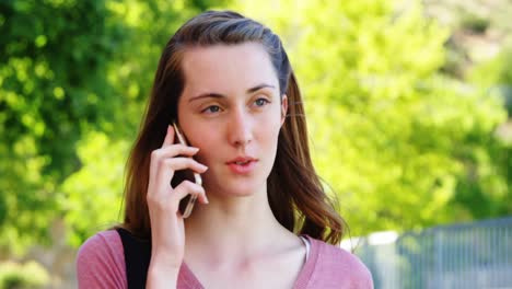 una estudiante hablando por teléfono móvil.