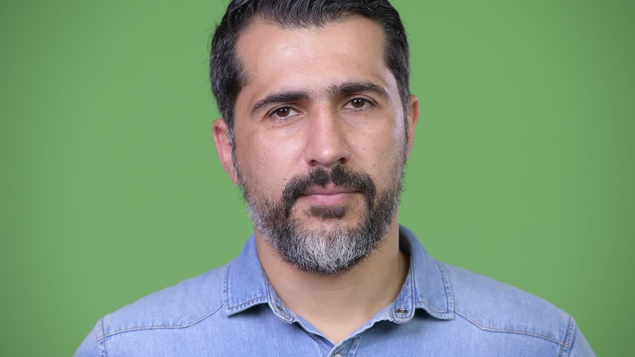 Uomo persiano barbuto e bello su sfondo verde