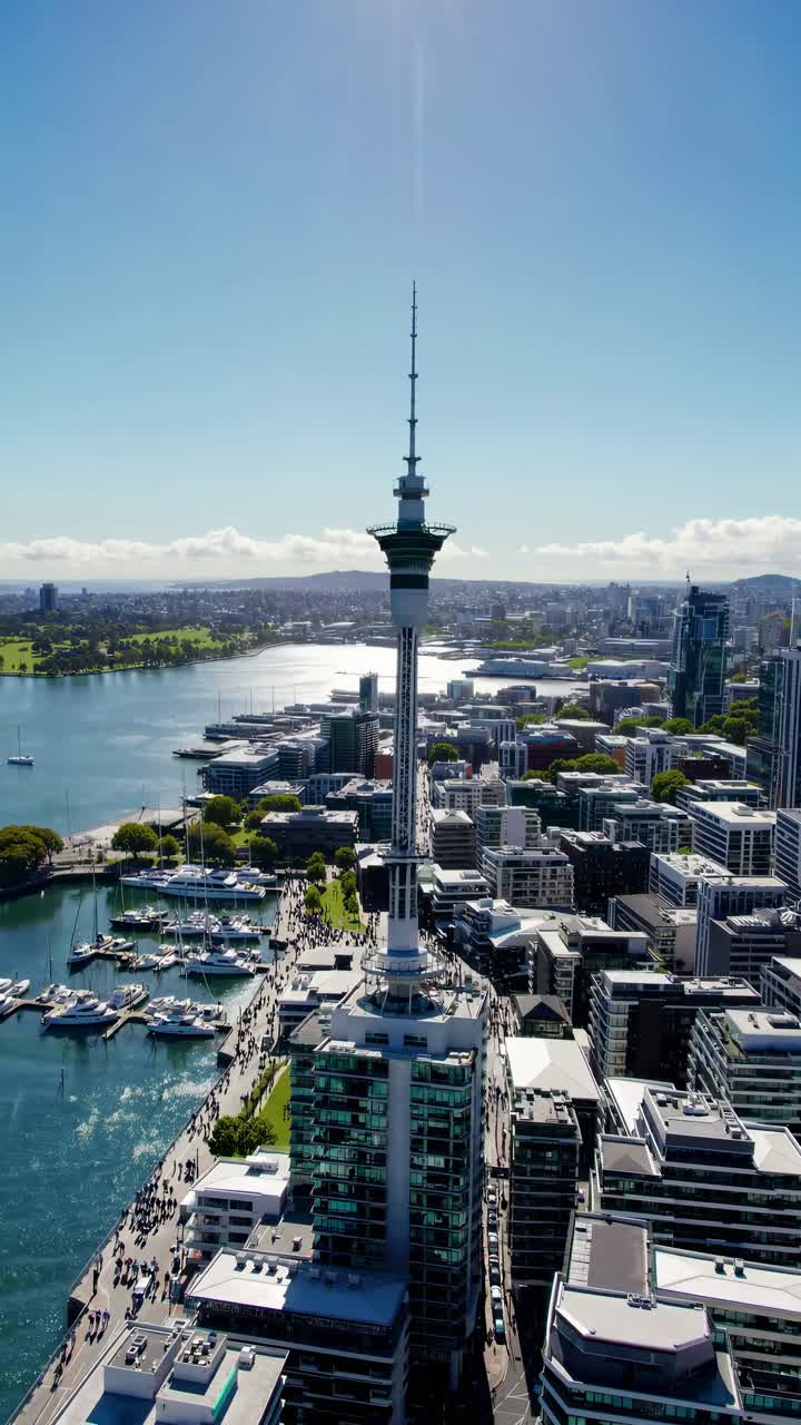 Video aereo di un paesaggio urbano con una torre prominente, circondata da acqua ed edifici urbani