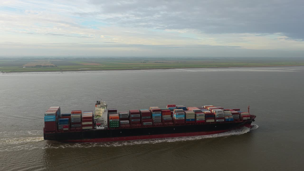 Aerial drone shot of large cargo ship cruising the Elbe River, Germany
