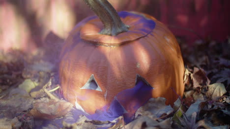 rotten halloween jack-o'-lantern with a thin cloud of purple smoke drifting out