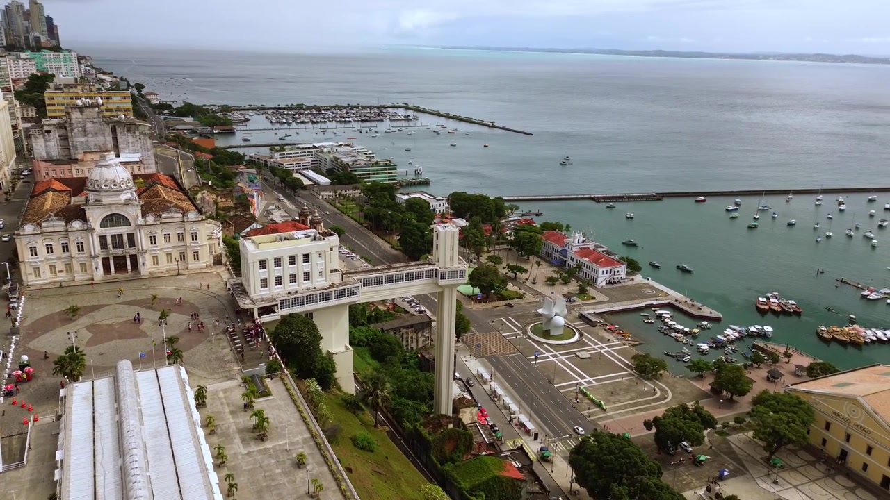 Luftaufnahme per Drohne, die den Lacerda-Aufzug, den historischen Mercado Modelo und Boote in der wunderschönen Bucht von Todos os Santos in Salvador, Bahia, Brasilien enthüllt