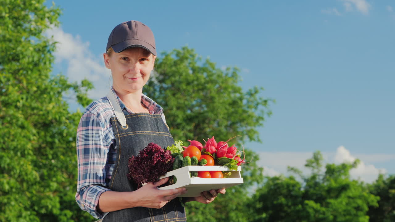 retrato de una agricultora con una caja de verduras frescas de su jardín