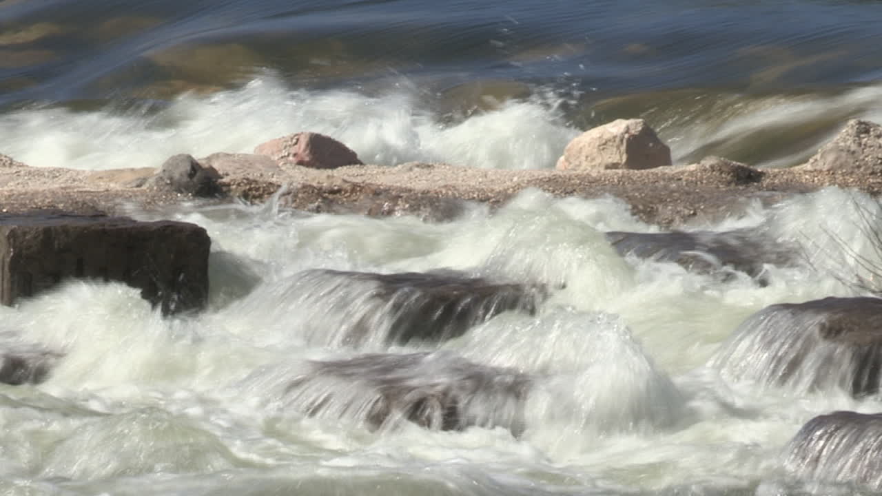 Strong river current crashing against the containment barriers
