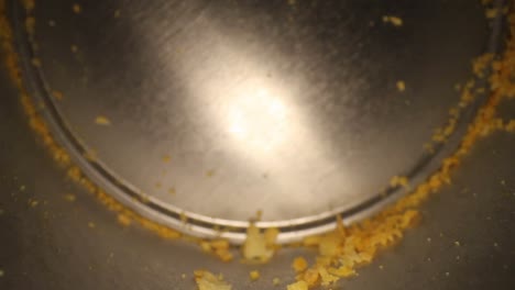 starting at bottom of an empty chip can with great detail in the metal, pulling away from bottom, many chip crumbs visible - using a wide angle probe lens, getting unique look