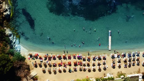 top down aerial footage of beautiful turquoise beach covered with umbrella