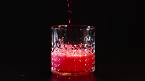 red drink poured into a patterned glass