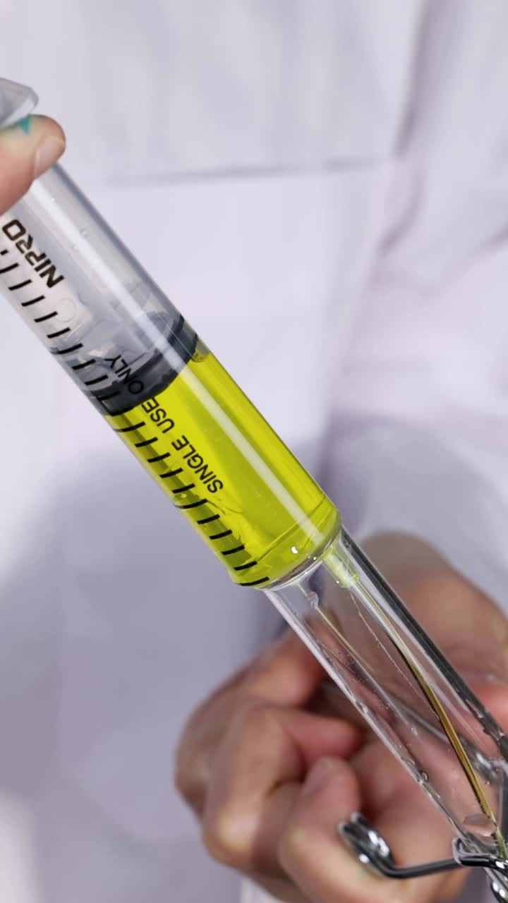 el científico lleva a cabo un experimento con una jeringa y un vaso