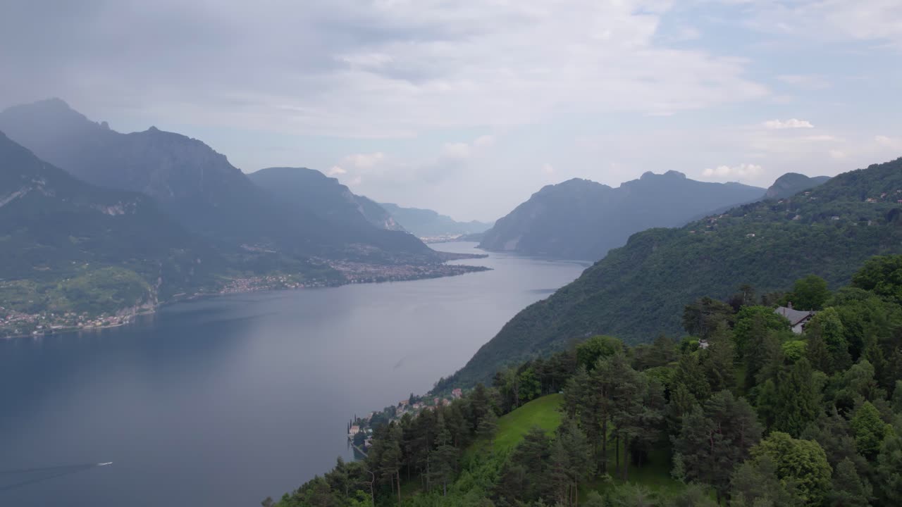 paralaje del lago como rodeado de montañas boscosas y pequeños pueblos