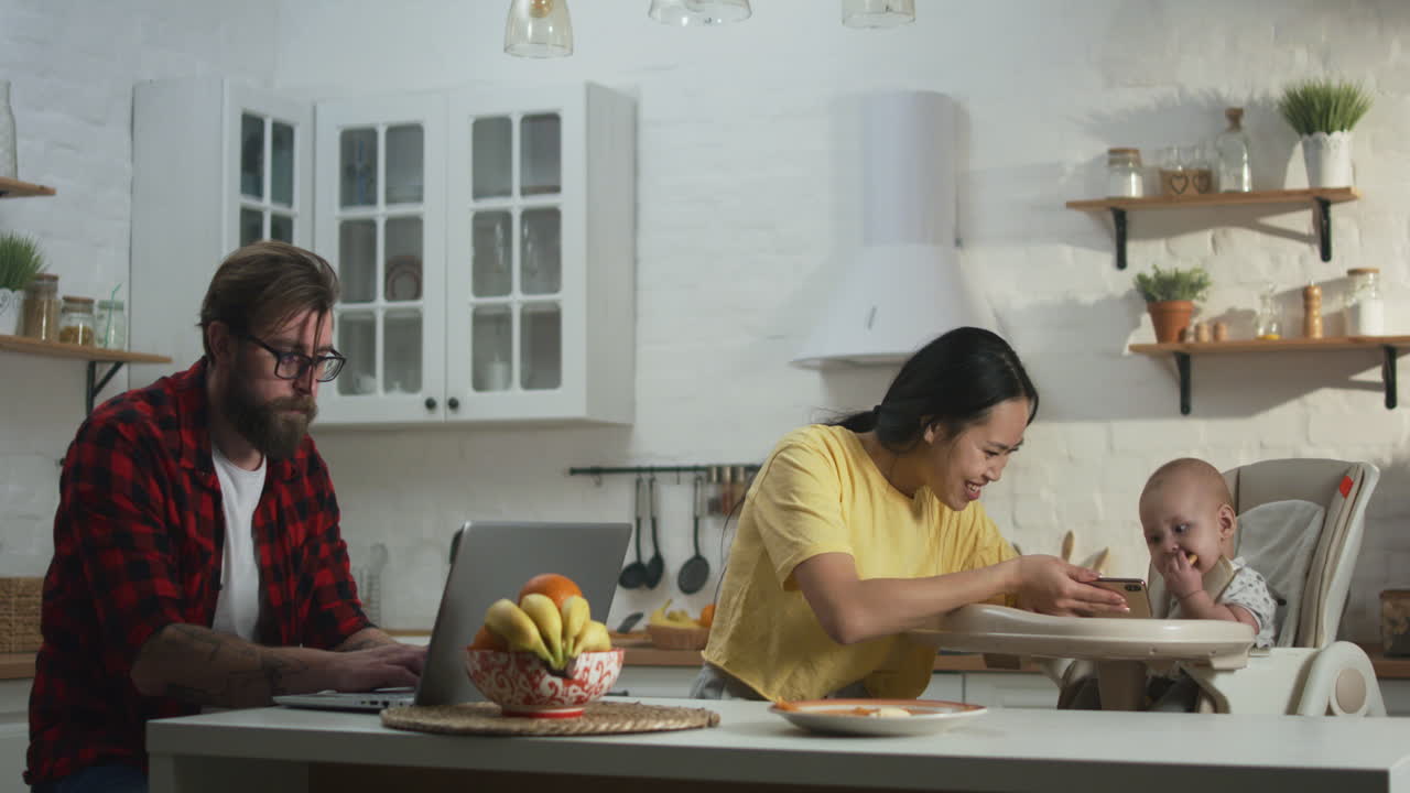 Working parents in the kitchen with a baby