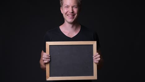 happy man holding empty blackboard