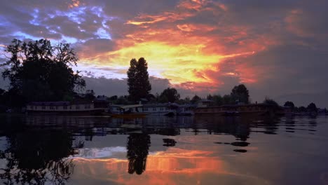 scenic view of large floating houseboats in idyllic lake over dramatic sunset sky