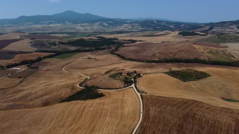 Ubicación-De-La-Película-Aérea-Del-Gladiador-Protagonizada-Por-Russell-Crowe-En-Val-D&#39;orcia-Cerca-De-Siena,-Florencia-Y-Pienza-Con-Una-Avenida-De-Cipreses-Con-Campos-De-Cultivo-De-Trigo-Cosechados-En-Colinas-Panorámicas-De-Verano