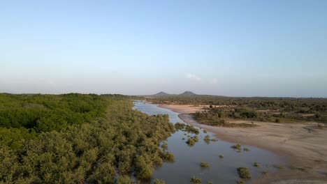 il drone segue questo corpo d'acqua con foresta di mangrovie sul lato sinistro e banchi di sabbia sulla destra rivelando anche le montagne tetas de maria guevara, porlamar, isola margarita, venezuela