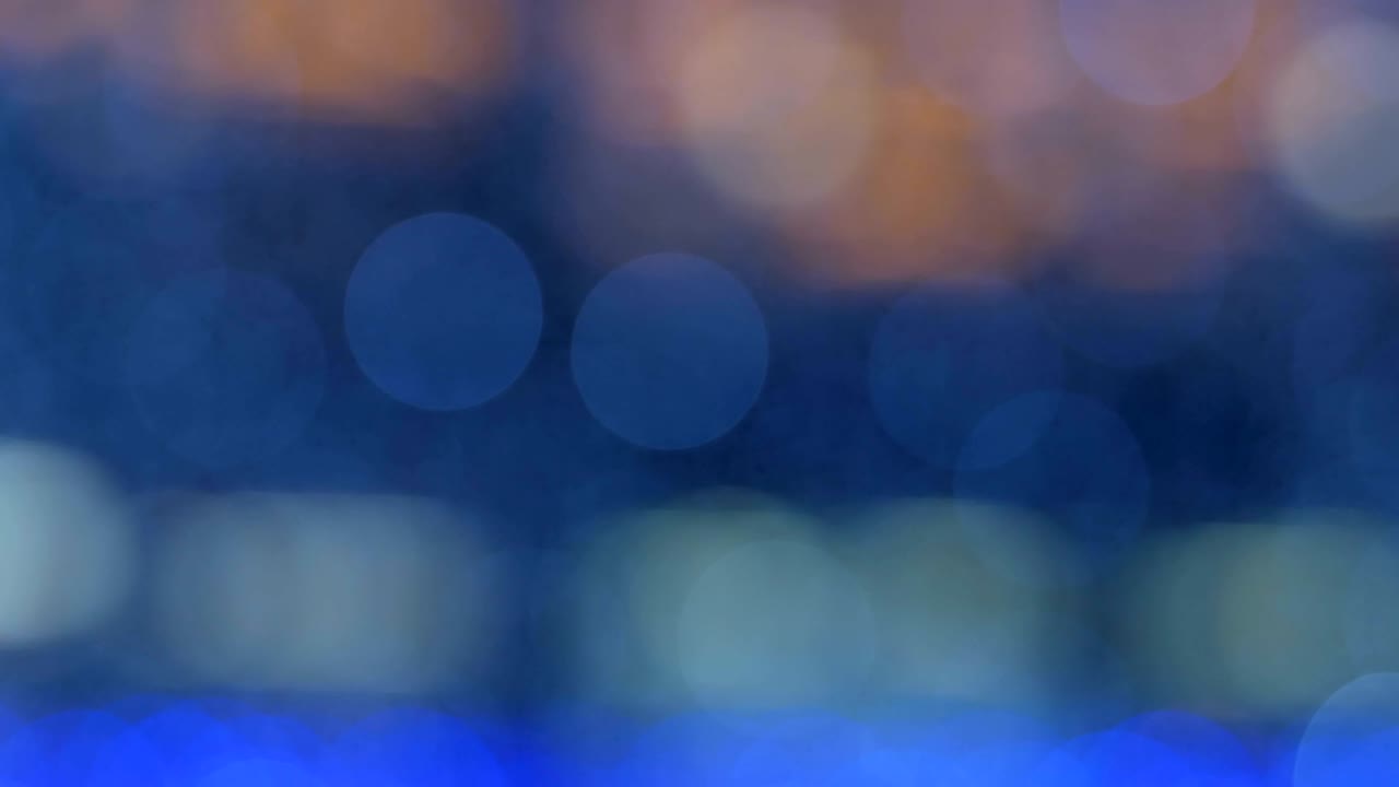 밤의 추상적인 배경은 멋진 보케로 분해되어 있습니다. 흐릿한 크리스마스 조명 보케. 흐릿함을 가로질러 팬.