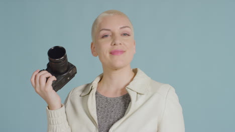 female caucasian model posing with dslr against blue backdrop 02