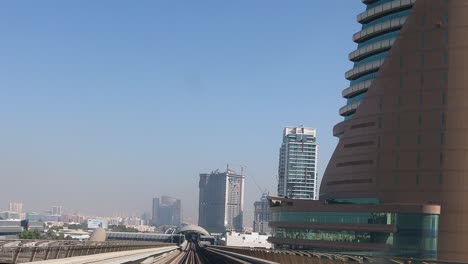 sistema de metro. vista desde la ventana del vagón del metro en dubái temprano en la mañana. tren de la estación subterránea pasa por los rascacielos. lapso de tiempo